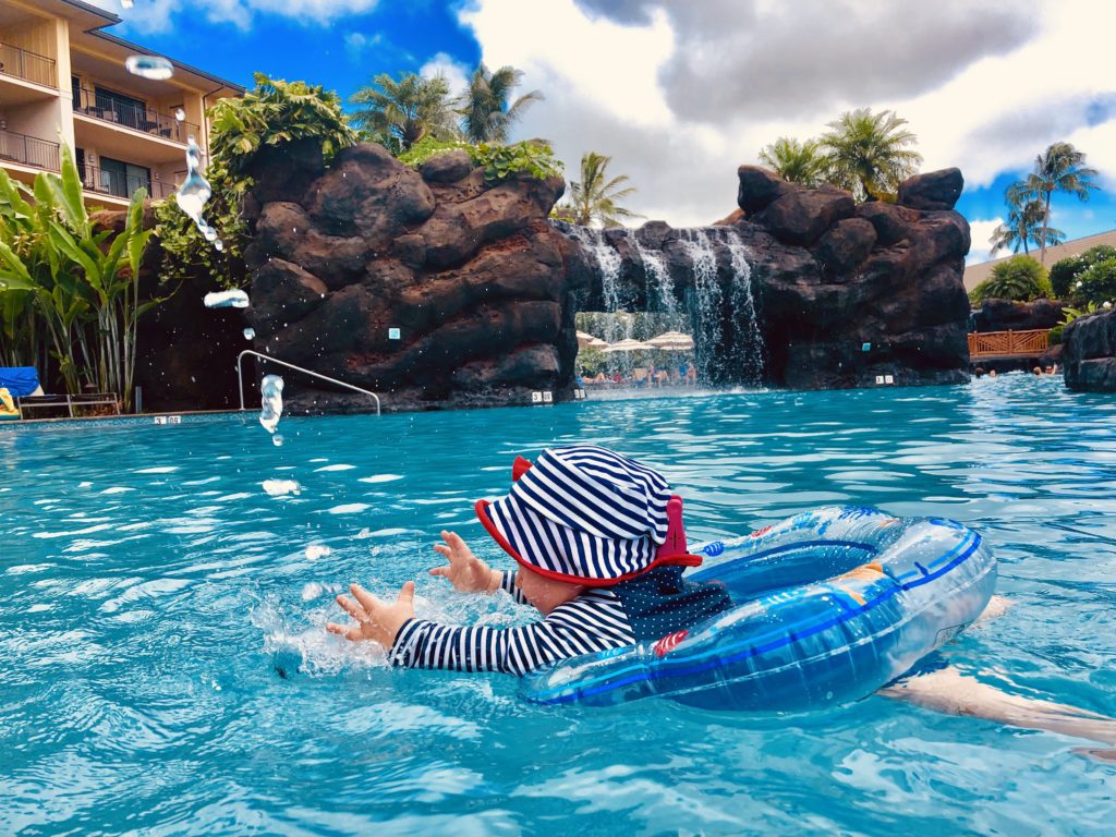 Im Schwimmring mit Wasserfontainen spielen