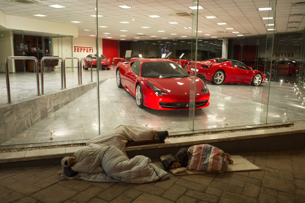 Arm und reich beieinander. Obdachlose in Kapstadt schlafen vor der Ferrari Filiale